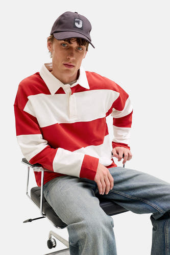 Pull rouge à col rond de ORIGINALS BY JACK & JONES, avec des rayures blanches horizontales, porté avec une casquette foncée et un jean.