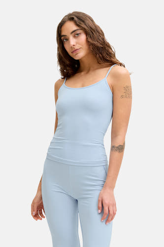 Haut bleu à fines bretelles de JJXX, avec des tatouages de manches et un pantalon bleu assorti.