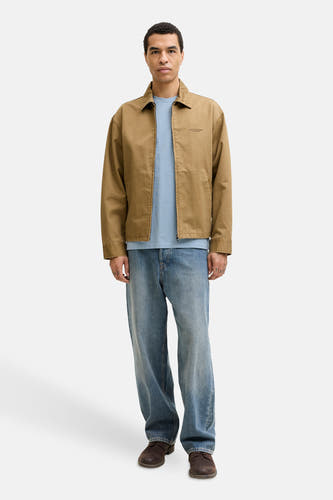 Blauw T-shirt met korte mouwen van PREMIUM BLUE by JACK & JONES, gedragen onder een bruin jasje met blauwe jeans en bruine schoenen.
