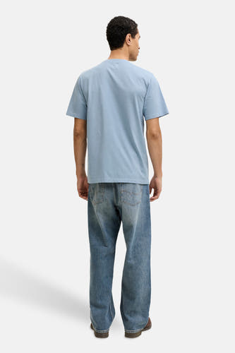 T-shirt bleu à manches courtes de PREMIUM BLUE by JACK & JONES, dos, combiné avec un jean ample et des chaussures marron.