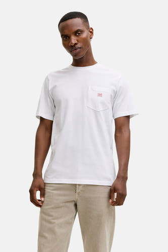 T-shirt blanc à manches courtes de PREMIUM BLUE by JACK & JONES, porté sous une chemise gris clair à manches longues et un pantalon beige.