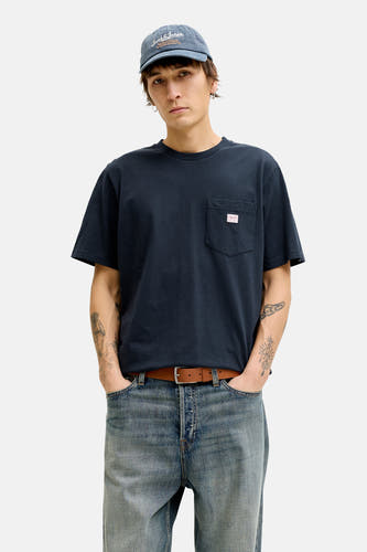 T-shirt bleu à manches courtes de PREMIUM BLUE by JACK & JONES, porté avec une veste marron et un jean.