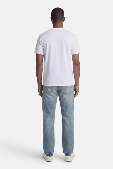Wit T-shirt van PREMIUM BLUE by JACK & JONES, achterkant gezien, gecombineerd met jeans en witte sneakers.