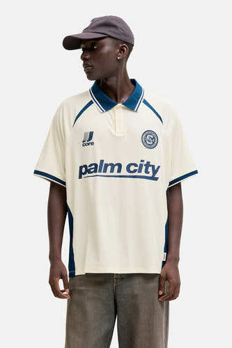 Polo blanche à manches courtes de CORE BY JACK & JONES, avec des accents bleu marine sur le col et les manches.