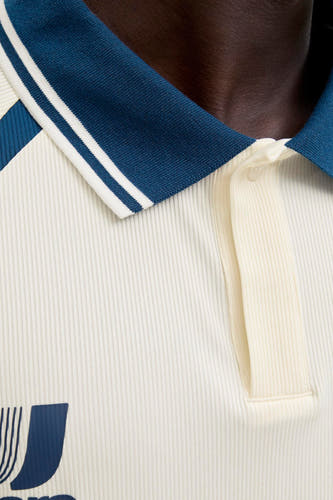 Polo blanche à manches courtes de CORE BY JACK & JONES, avec un col bleu marine et une structure côtelée.