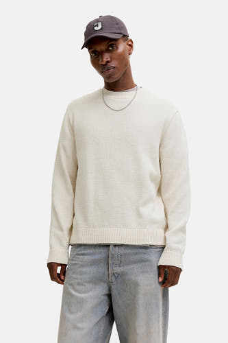 Pull de couleur écru à col rond de ORIGINALS BY JACK & JONES, avec une veste aspect cuir, un jean ample et des chaussures noires.