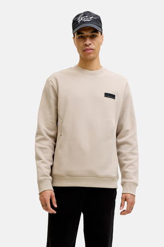 Pull beige de CORE BY JACK & JONES, à manches longues et avec un petit écusson logo sur la poitrine.