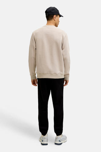 Pull beige de CORE BY JACK & JONES, vu de dos, avec manches longues et pantalon noir.