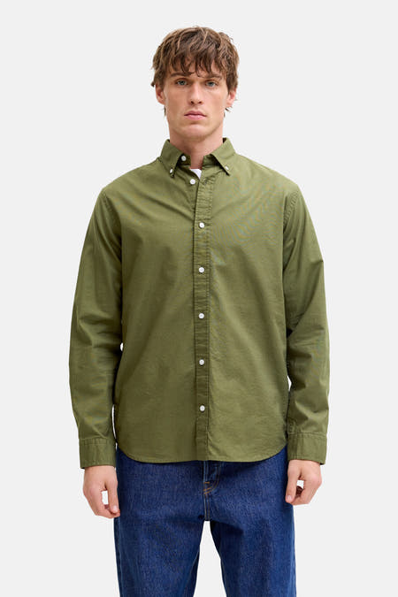 Chemise verte à manches longues de PREMIUM BLUE by JACK & JONES, avec boutons blancs, portée sur un t-shirt blanc.