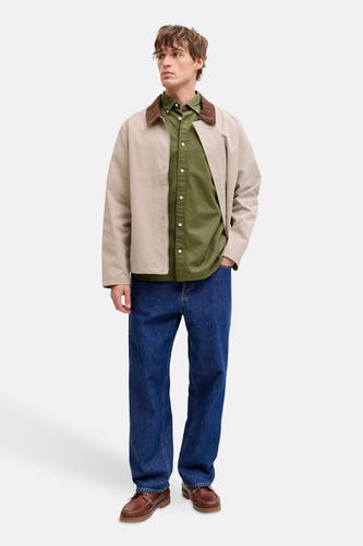Groen hemd met lange mouwen van PREMIUM BLUE by JACK & JONES, gedragen met een beige jas en blauwe jeans.
