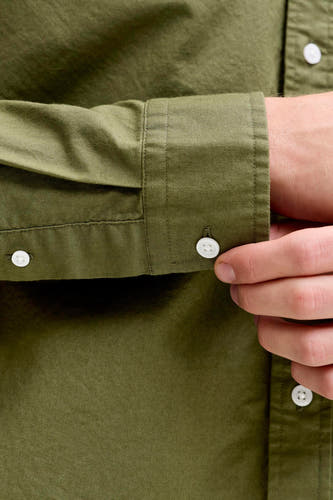 Chemise verte à manches longues pour homme de PREMIUM BLUE by JACK & JONES, avec un homme qui ferme le poignet.