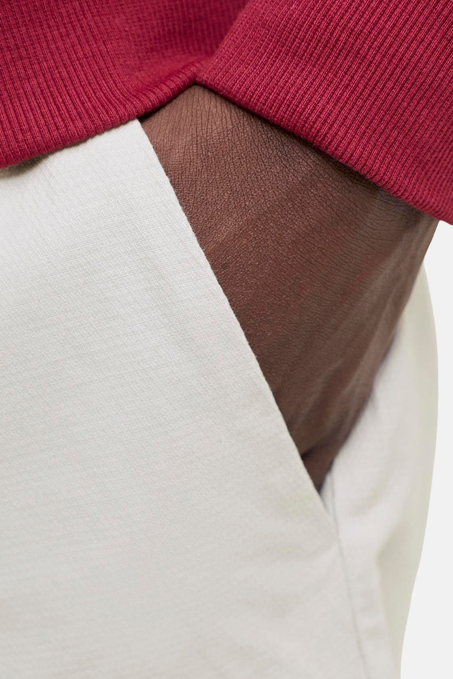 Short beige de JACK & JONES JEANS INTELLIGENCE avec motif subtilement tissé, poche pour les mains et t-shirt rouge côtelé.