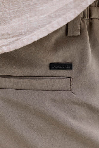 Pantalon chino gris de PREMIUM by JACK & JONES, gros plan sur la poche avec logo.
