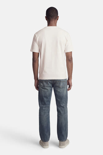 T-shirt blanc à manches courtes de ORIGINALS BY JACK & JONES, avec un motif uni et porté avec un jean bleu et des chaussures en daim.