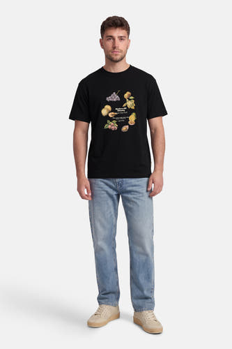 T-shirt noir de ORIGINALS BY JACK & JONES avec imprimé coloré de fruits et de coquillages, porté par un homme avec un jean clair et des baskets beiges.