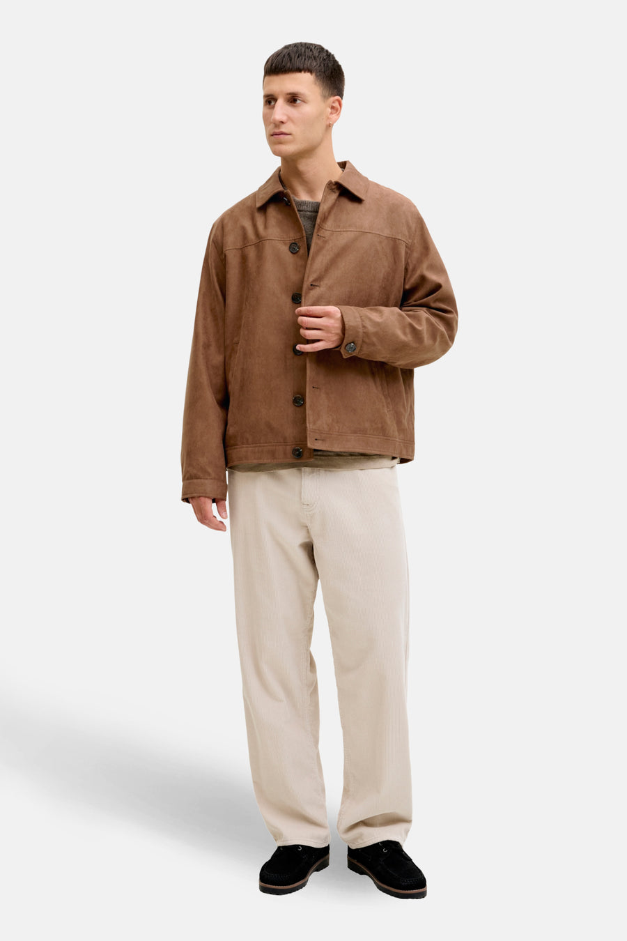 Man met bruine jas en beige corduroy broek.