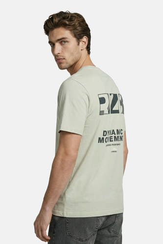 T-shirt vert de JJREBEL avec un imprimé foncé, partiellement en grille, dans le dos, porté par un homme avec un jean foncé.