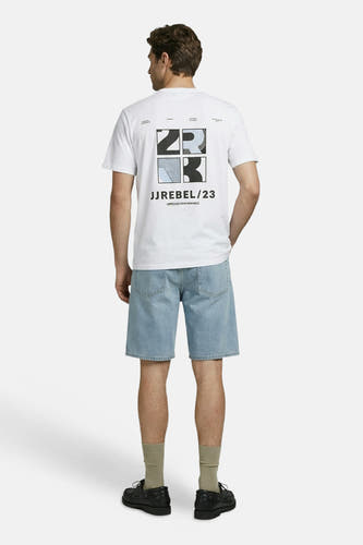T-shirt blanc JJREBEL avec un imprimé graphique au dos des chiffres '2' et '3' et 'JJREBEL/23'. Un homme le porte de dos avec un short en jean.