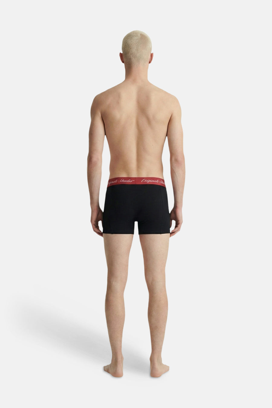 Boxer noir Jack & Jones avec ceinture rouge ornée du texte 'Originals Studio', vu de dos sur un homme.