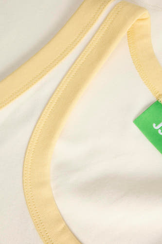 Débardeur écru de JJXX avec passepoil jaune et une étiquette verte.