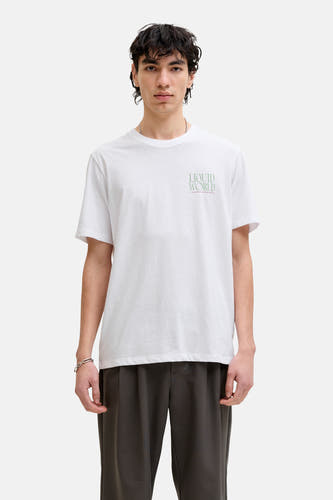 T-shirt blanc de ORIGINALS BY JACK & JONES, avec un petit imprimé texte, combiné avec un pantalon foncé et des baskets marron.