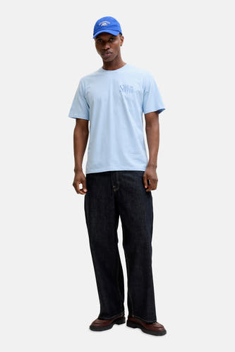 Blauw T-shirt van ORIGINALS BY JACK & JONES, met korte mouwen en een tekstprint, gecombineerd met een blauwe pet en donkere jeans.