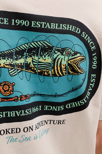 T-shirt beige de ORIGINALS BY JACK & JONES, avec un imprimé graphique d'un poisson et d'une canne à pêche.