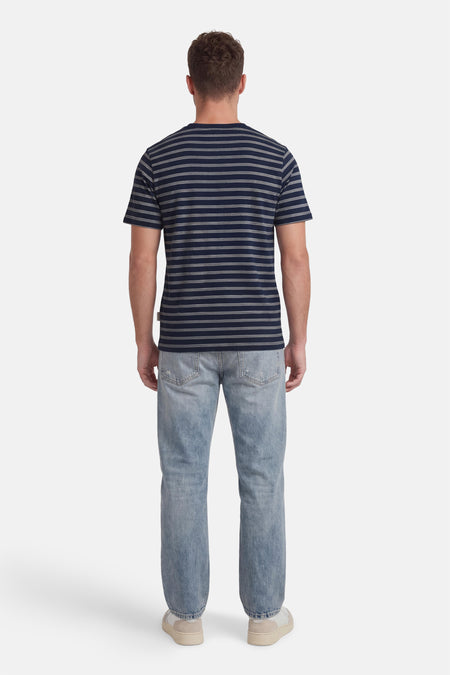 Blauwe gestreepte korte mouw t-shirt van ORIGINALS BY JACK & JONES, achterzijde, met witte strepen en ronde hals, gedragen met lichtblauwe jeans en beige sneakers