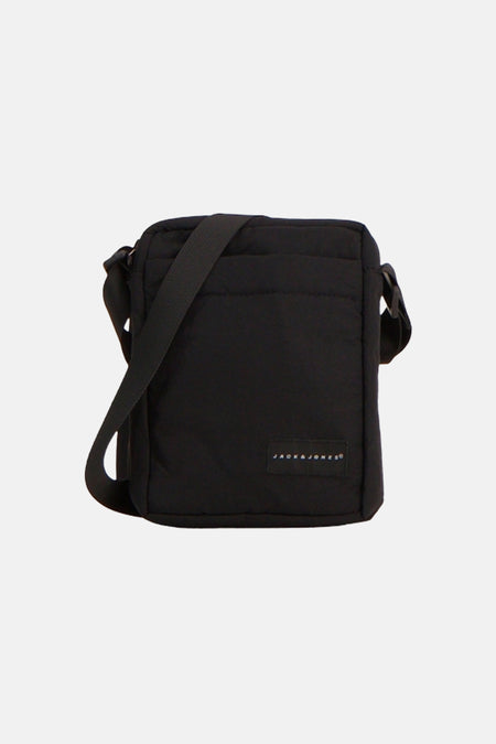 Sac à bandoulière noir matelassé d'ACCESSORIES BY JACK & JONES avec une bandoulière réglable et une petite étiquette de marque sur le devant.