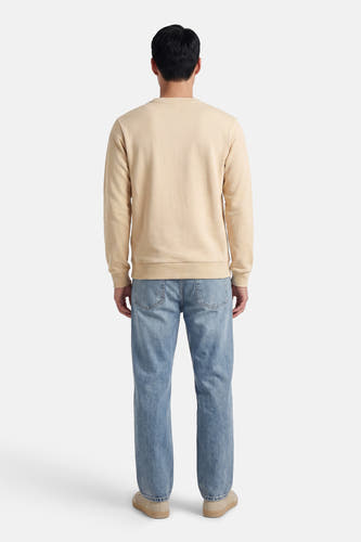 Pull beige de CORE BY JACK & JONES, à manches longues, combiné avec un jean et des chaussures dans un style décontracté, vu de dos.