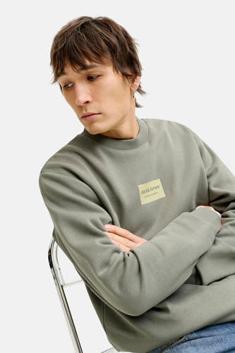 Pull vert de CORE BY JACK & JONES, avec col rond, manches longues et une étiquette sur la poitrine.