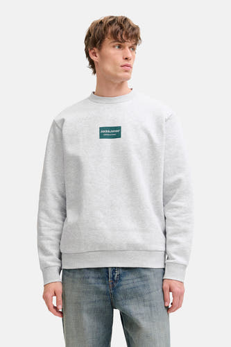 Pull gris à col rond de CORE BY JACK & JONES, avec logo sur la poitrine, combiné avec un jean.