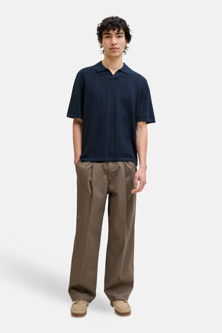 Blauwe polo van ORIGINALS BY JACK & JONES met een geweven patroon, gedragen met een bruine broek en beige mocassins.