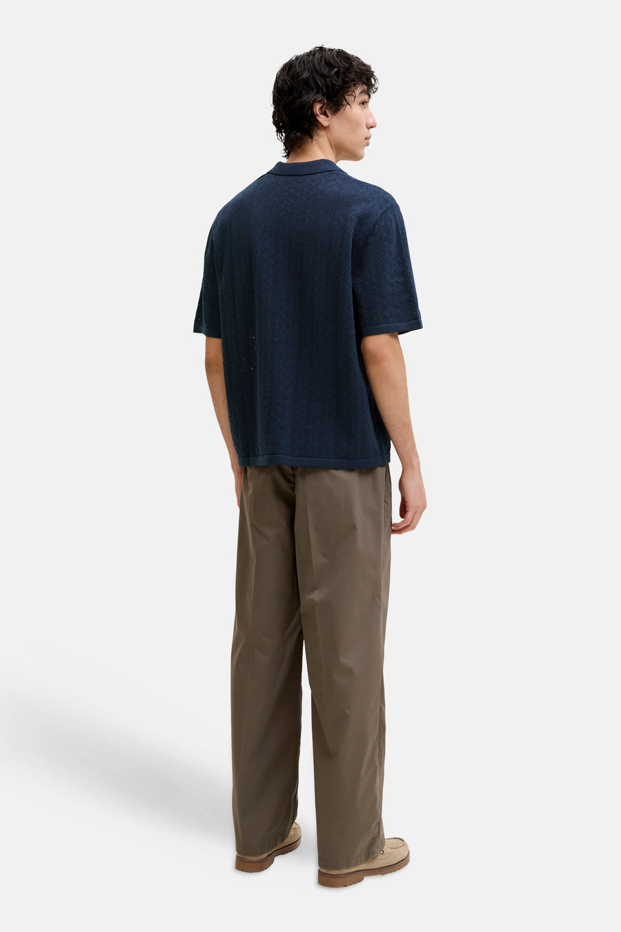 Polo bleu de ORIGINALS BY JACK & JONES avec un motif chevron tricoté, porté par un homme avec un pantalon marron, vue arrière.