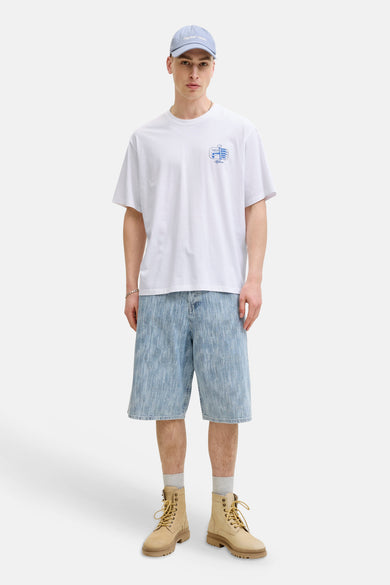 Witte korte mouw T-shirt met klein blauw logo op borst van ORIGINALS BY JACK & JONES, gedragen met lichtblauwe denim shorts en beige laarzen, front view.