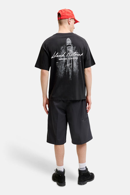T-shirt noir à manches courtes de CORE BY JACK & JONES, avec un imprimé graphique gris d'un yacht et le texte 'Island Retreat' au dos.