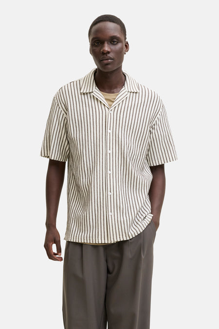 Bruin gestreept korte mouwen overhemd van PREMIUM by JACK & JONES, met witte knopen en open kraag, gedragen met beige onderhemd en grijze broek, front view.