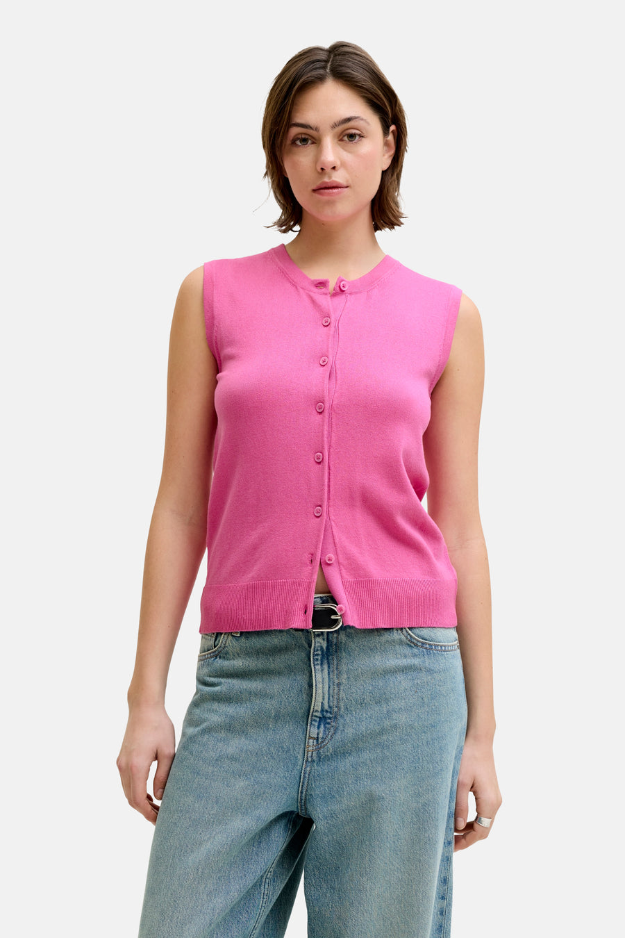 Débardeur rose de JJXX, avec fermeture à boutons, combiné avec un jean bleu et des chaussures noires.