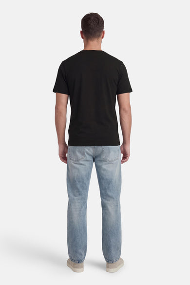 T-shirt noir à manches courtes de CORE BY JACK & JONES, vue de dos avec jean et chaussures.