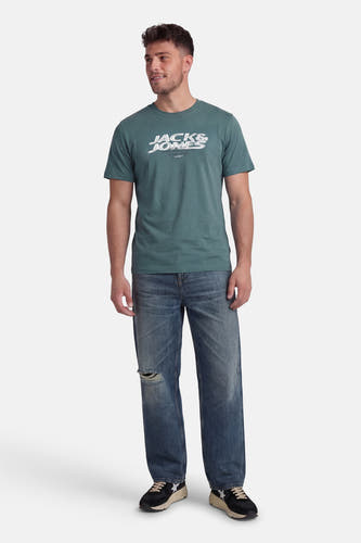 Groen T-shirt met korte mouwen van CORE BY JACK & JONES, gedragen met een blauwe jeans en zwarte sneakers.
