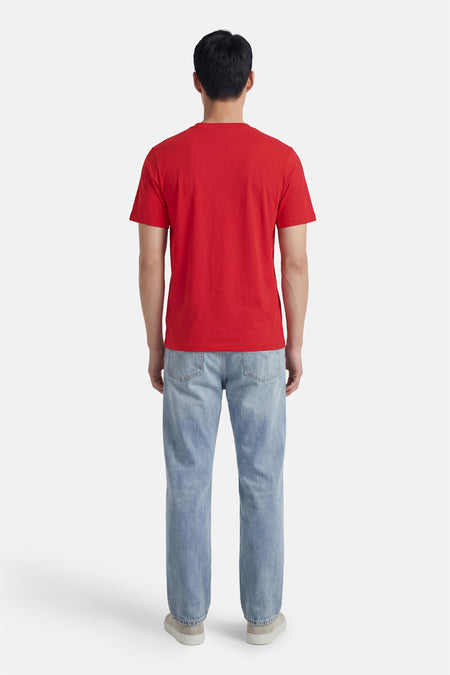 T-shirt rouge à manches courtes de ORIGINALS BY JACK & JONES, avec un design uni, porté avec un jean bleu et des baskets, vu de dos.