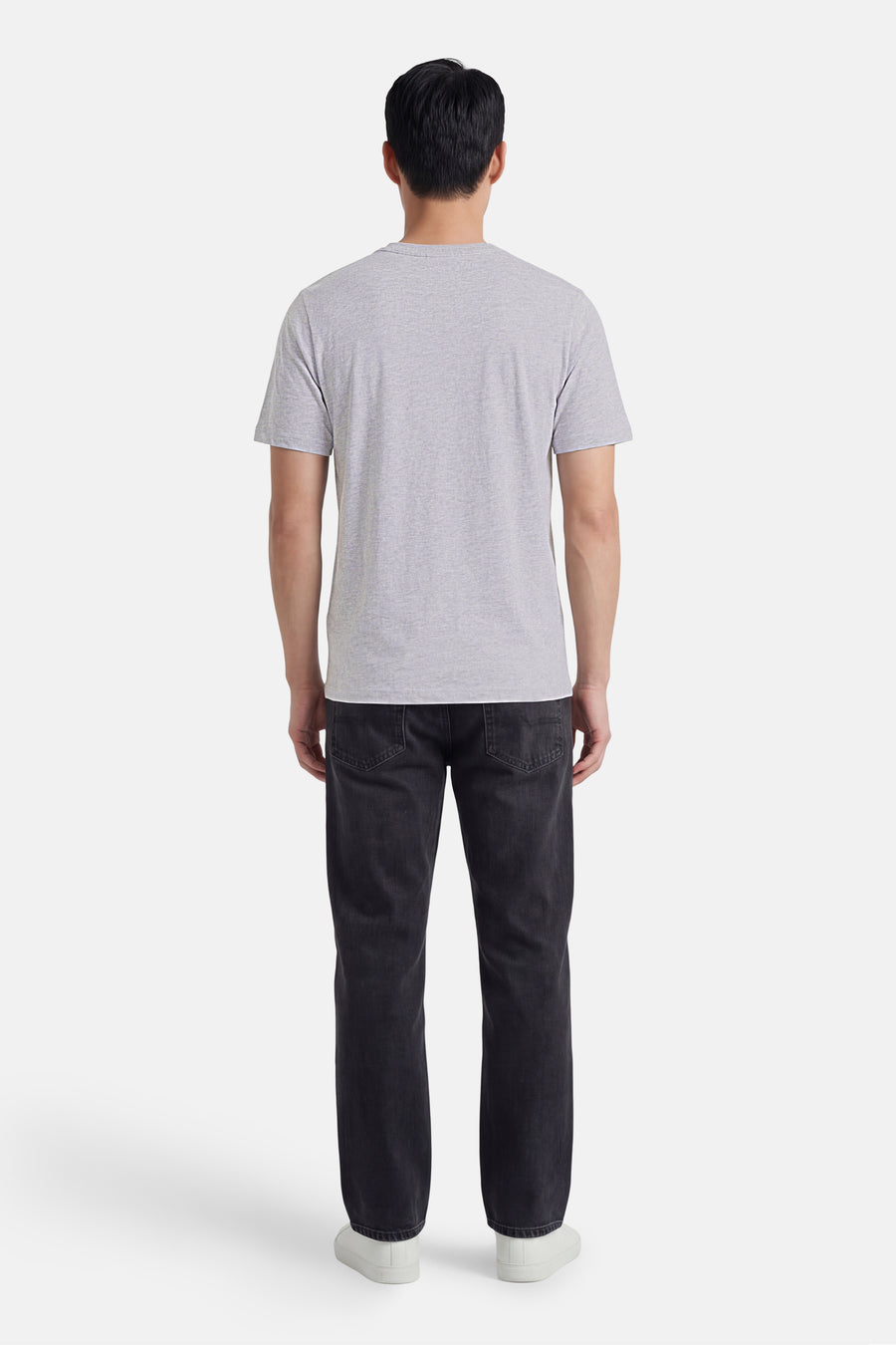 T-shirt gris de CORE BY JACK & JONES, vue arrière d'un homme avec un jean foncé et des baskets blanches.