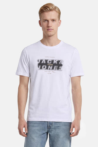 Wit T-shirt van CORE BY JACK & JONES met gesprayd zwart logo op de borst, gedragen door een man.