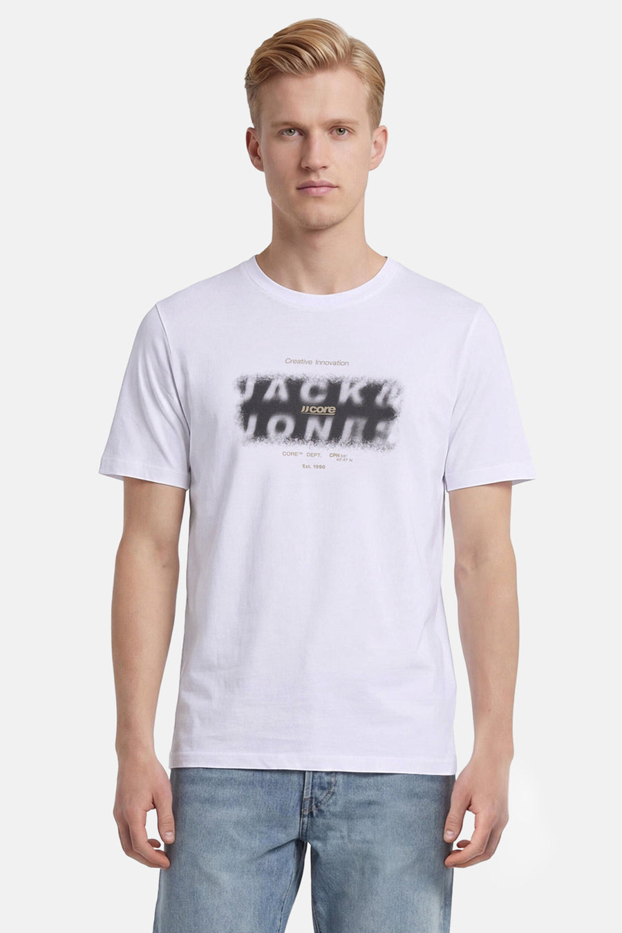 Wit T-shirt van CORE BY JACK & JONES met gesprayd zwart logo op de borst, gedragen door een man.