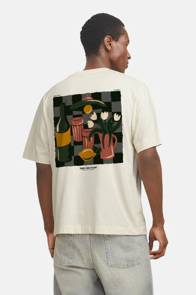 T-shirt écru à manches courtes d'ORIGINALS BY JACK & JONES, avec une impression de nature morte sur le dos, porté avec un jean.