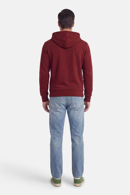 Pull à capuche rouge de ORIGINALS BY JACK & JONES, vu de dos, avec un jean bleu clair et des chaussures vertes.