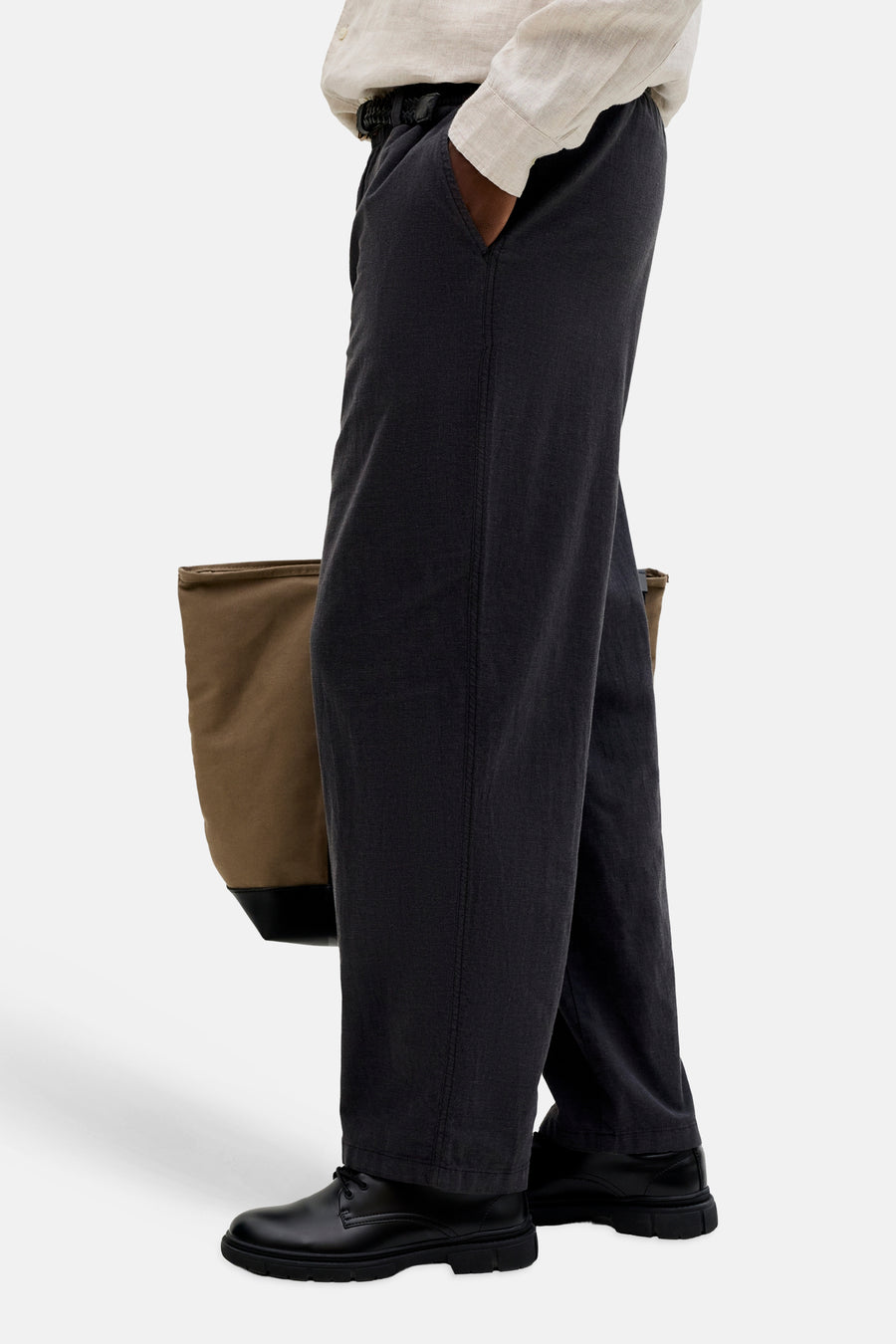 Pantalon de saison noir de JACK & JONES JEANS INTELLIGENCE avec taille élastique et coupe décontractée, porté avec une chemise claire, des chaussures noires et un sac marron.