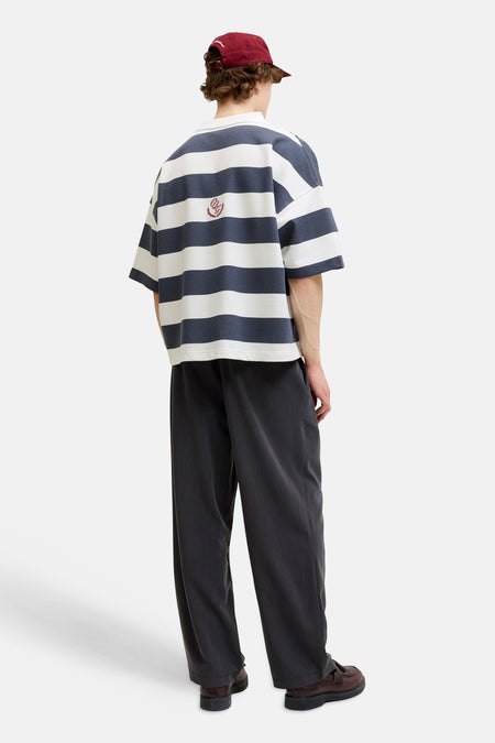 Pull rayé blanc et bleu foncé avec col blanc et logo brodé d'ORIGINALS BY JACK & JONES, porté par un homme avec un pantalon foncé et une casquette rouge.