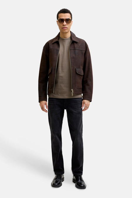 Bruine korte mouwen t-shirt van PREMIUM by JACK & JONES, gedragen onder donkere leren jas, met zwarte jeans en glimmende schoenen, front view.
