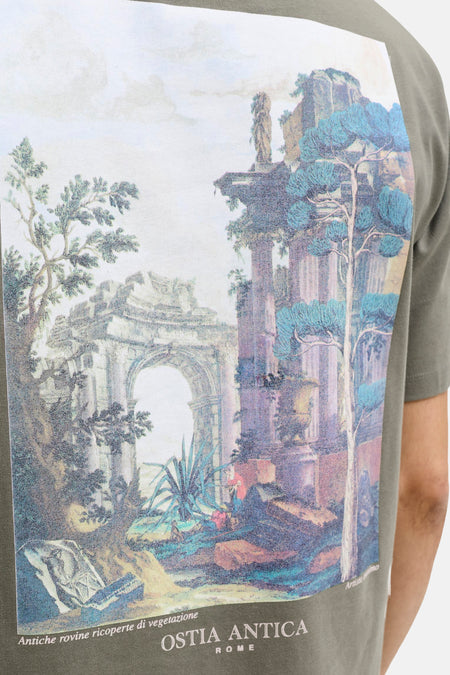 Groene korte mouw T-shirt van PREMIUM by JACK & JONES met groot landschapprint van Ostia Antica, Rome, in vintage stijl, zijwaarts op model.